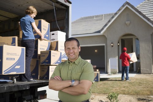 Van movers securing household items with protective blankets